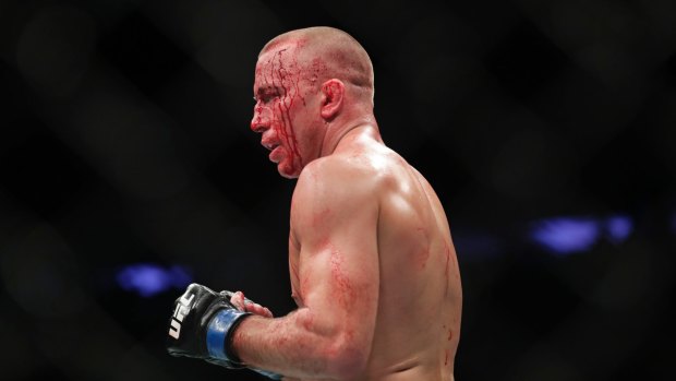 Legend: Georges St-Pierre, of Canada, is bloodied as he faces England's Michael Bisping.