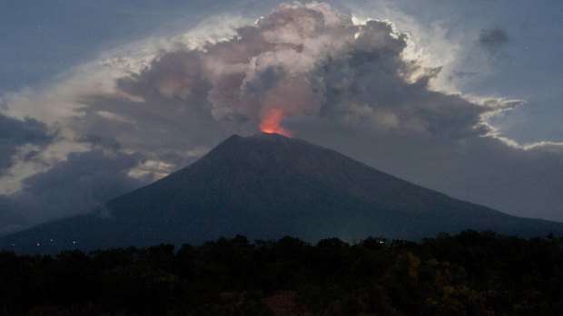 Mount Agung's crater glows red from the lava.