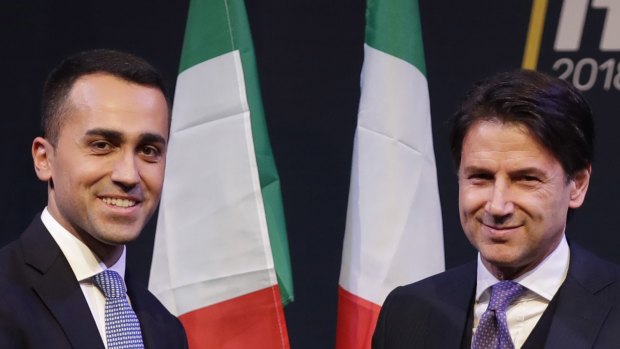 Giuseppe Conte, right, shakes hands with leader of the Five-Star Movement, Luigi Di Maio, during a meeting in Rome. 