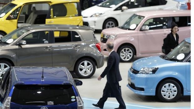 A visitor walks past Toyota Motor Corp. vehicles on display at the company's showroom in Tokyo, Japan. This week, the carmaker announced second-quarter earnings that beat analysts estimates and said a weaker yen would propel net income to rise about 10 percent this fiscal year. Photographer: Kiyoshi Ota/Bloomberg
