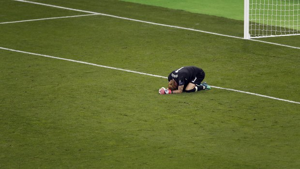 Heartbroken: Karius goes to the ground at the final whistle as Real Madrid win 3-1.