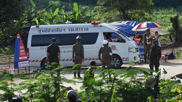 An ambulance carrying the 5th person to be rescued from Tham Luang cave drives past the caves park entrance.