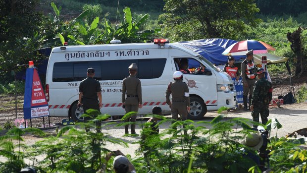 An ambulance carrying the 5th person to be rescued from Tham Luang cave drives past the caves park entrance.