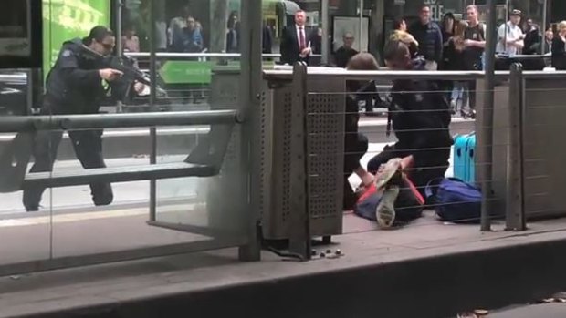 Police with their guns drawn stopped a tram and surrounded the man on Collins Street.