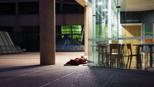 A homeless man spends the night outside the State Library of NSW.