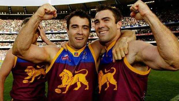 Chris and Brad Scott celebrate the Brisbane Lions' 2002 flag wearing their famous premiership guernsey.