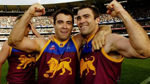 Chris and Brad Scott celebrate the Brisbane Lions' 2002 flag wearing their famous premiership guernsey.