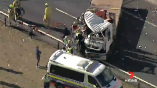 A driver is trapped inside a truck after a crash between multiple vehicles.