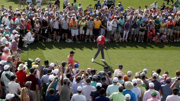 Tigermania: Tiger Woods hits his tee shot in front of a huge crowd during practice.