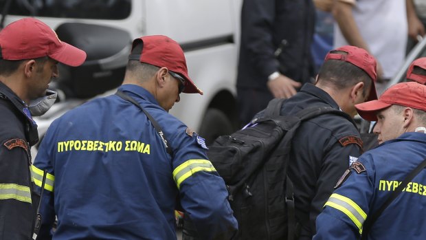 Firefighters remove a dead body in Mati, east of Athens.