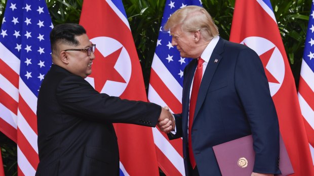 Kim Jong-un and Donald Trump shake hands.