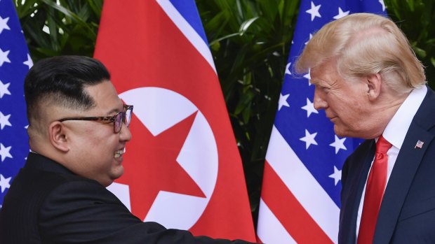 Kim Jong-un and Donald Trump shake hands.