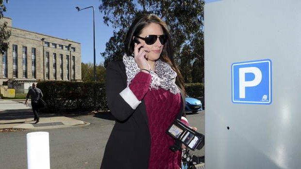 Emilie Rohan uses her phone to call the help line when the parking
 machine ate her coins.