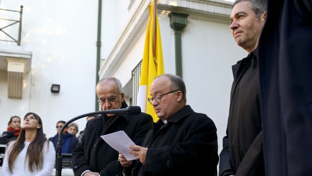 Archbishop Charles Scicluna, holding paper, Spanish Monsignor Jordi Bertomeu, right, and Papal Nuncio Ivo Scapolo, left, give a press conference in Santiago, Chile.