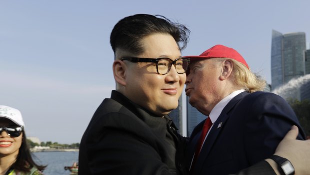Kim Jong-un and Donald Trump impersonators Howard X, center, and Dennis Alan, right, embrace in Merlion Park in Singapore last Friday.