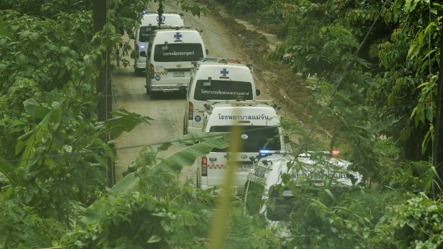 Five ambulances drive up the road leading to Tham Luang cave during the rescue operation. 
