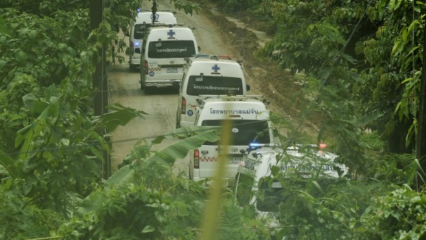 Five ambulances drive up the road leading to Tham Luang cave during the rescue operation. 