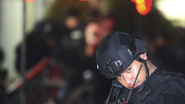 An Indonesian police officer stands guard in front of an apartment building after an explosion in Sidoarjo, East Java.