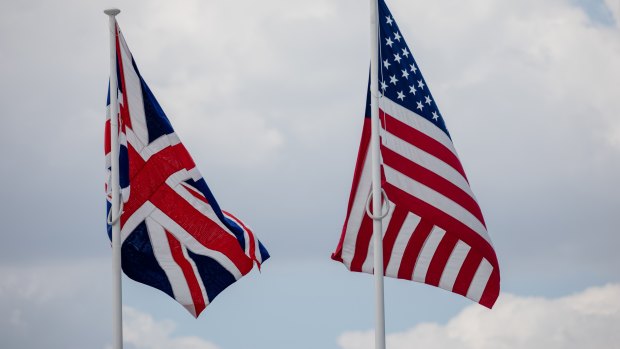 A British Union flag, also known as the Union Jack, left, flies beside a US flag.