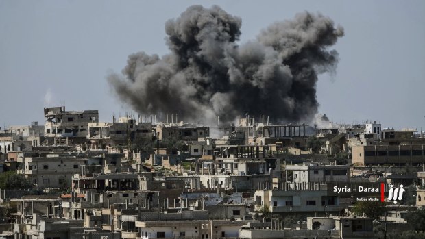 Smoke rises from buildings hit by Syrian government forces bombardment in Daraa province, southern Syria. 