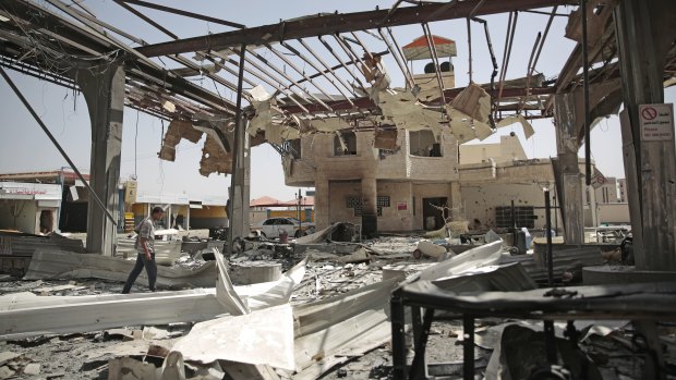 A Yemeni man walks among the rubble of a petrol station after it was hit by Saudi-led airstrikes in Sanaa in late May.