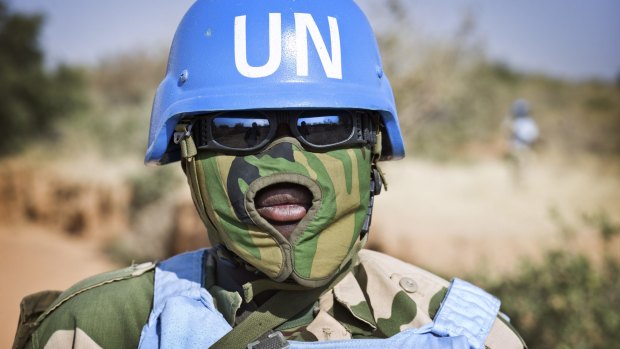 A peacekeeper protects his face from the heat and dust in Nyoro, in the Darfur region of Sudan.