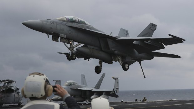 US Navy's F/A-18 Super Hornet fighter approaches the deck of the USS Carl Vinson.