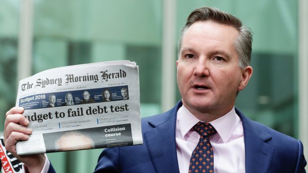 Shadow Treasurer Chris Bowen holds a copy of today's Sydney Morning Herald as he addresses the media ahead of budget night.