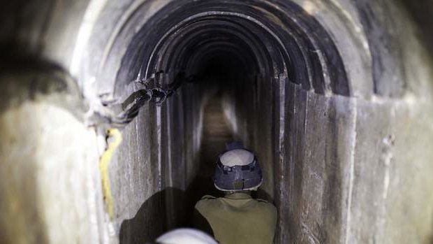 Israeli soldiers stand guard inside a tunnel exposed by the Israeli military near Kibbutz Ein Hashlosha, just outside the southern Gaza Strip.