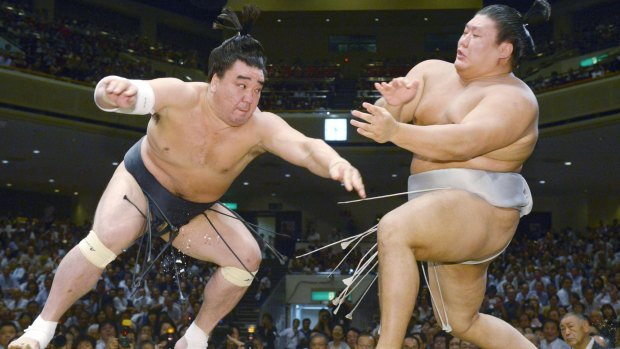 Mongolian sumo grand champion Harumafuji, left, pushes opponent Takanoiwa out of the ring to win their bout at the Autumn Grand Sumo Tournament in Tokyo in 2016.
