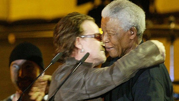 Former South African President Nelson Mandela is hugged by U2 lead singer Bono, at the Nelson Mandela AIDS Benefit Concert in 2003.