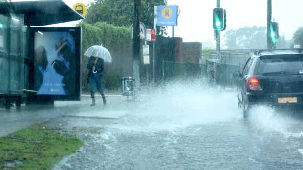 Commuter splashed by flash flooding at Petersham.
