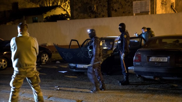 French Police officers search a car during a raid in Carcasona following an incident in Trebes, on Friday.