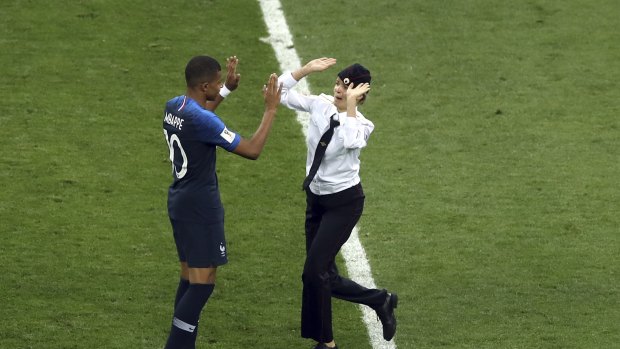 To be applauded: One of the pitch invaders gives a high ten to 
French star Kylian Mbappe.
