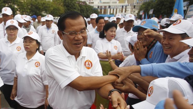 Cambodian Prime Minister Hun Sen, centre, greets supporters.