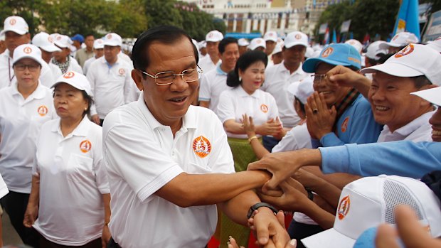 Cambodian Prime Minister Hun Sen, centre, greets supporters.