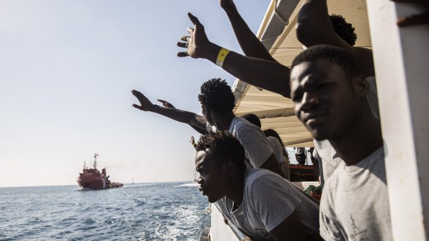 Migrants aboard the Open Arms aid boat, of Proactiva Open Arms Spanish NGO, react as the ship approaches the port of Barcelona, Spain.