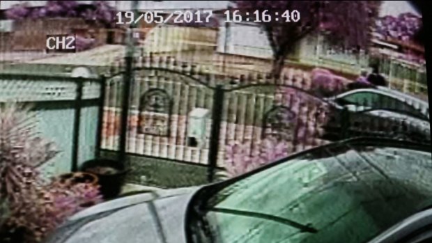 A man wearing black can be seen in the top right corner of this CCTV threatening the owner of a Mercedes station wagon with a knife.