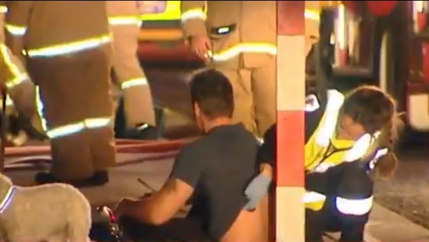 A man being treated by paramedics following a fire in Frankston South. 