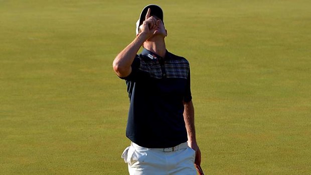 Justin Rose of England acknowledges his deceased father after putting on the 18th hole.