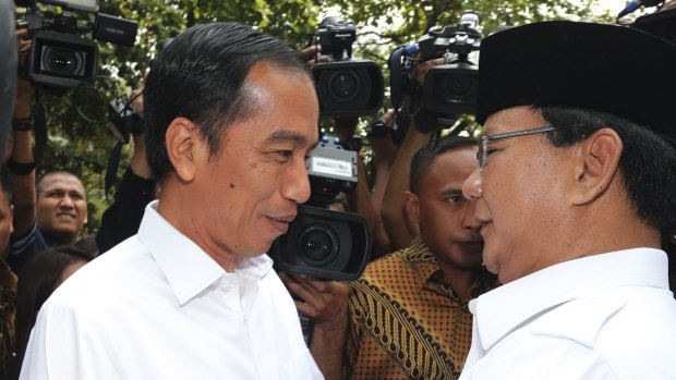 Indonesian President Joko Widodo, left, is embraced by his political rival Prabowo Subianto in 2014.