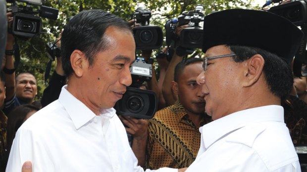 Indonesian President Joko Widodo, left, is embraced by his political rival Prabowo Subianto in 2014.