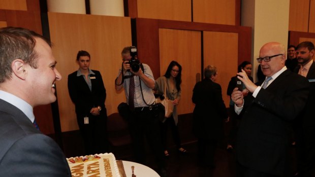 Attorney-General Senator George Brandis takes a photo of Human Rights Commissioner Tim Wilson.