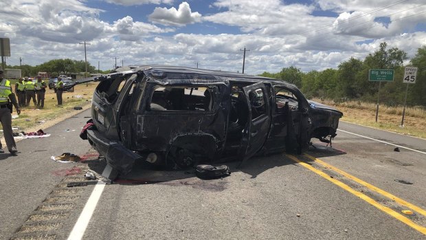 A heavily damaged SUV is seen on Texas Highway 85 in Big Wells, Texas, after crashing while carrying more than a dozen people fleeing from Border Patrol agents.