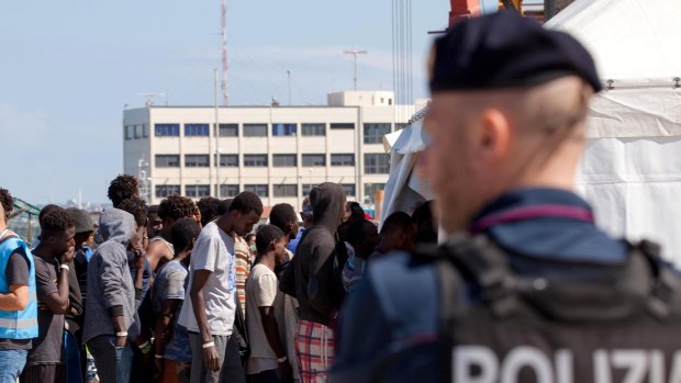 Migrants line-up after disembarking from a different vessel at the Reggio Calabria harbour on Saturday.