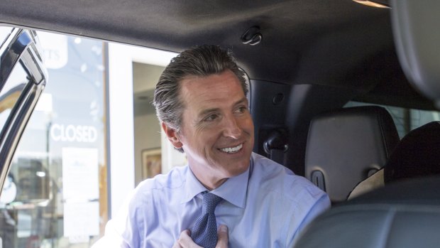 Gavin Newsom, Democratic candidate for governor of California, adjusts his tie while getting into a vehicle after voting at a polling location in Larkspur, California.