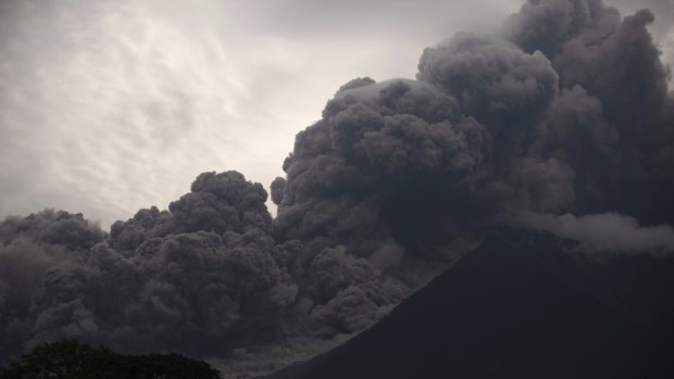 Volcan de Fuego, or Volcano of Fire, blows outs a thick cloud of ash.