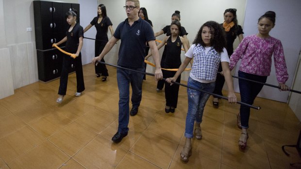 Colls, right, attends corporal expression class at Belankazar Modeling Academy in Caracas.
