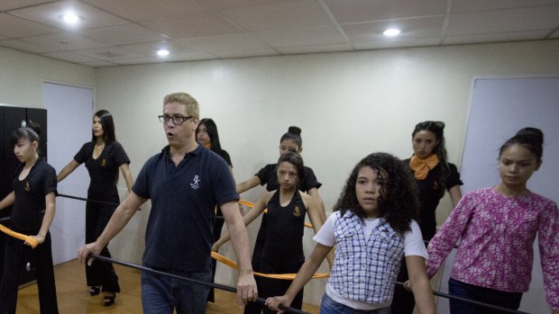 Colls, right, attends corporal expression class at Belankazar Modeling Academy in Caracas.
