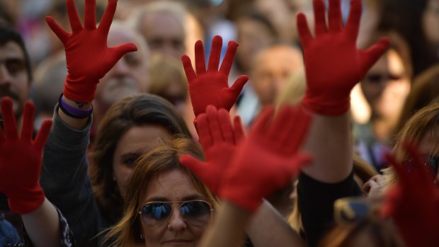 Women wearing red gloves while protesting at Plaza del Ayuntamiento square after three of five men granted bail after being acquitted of gang rape leave Pamplona's penitentiary, in Pamplona, northern Spain.